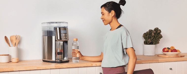 A woman uses a Breville AquaStation Chilled  Hot