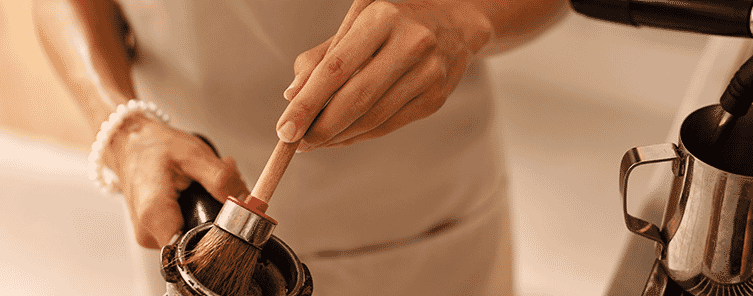 A lady cleaning out her coffee machine 