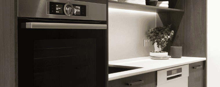 Butlers pantry in a dark timber veneer with a wall oven and dishwasher 