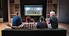 Group of fans watching a soccer moment on the TV and celebrating a goal sitting on the couch in the living room