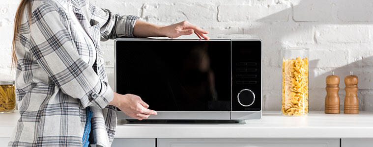 Closeup of a stainless steel microwave being opened
