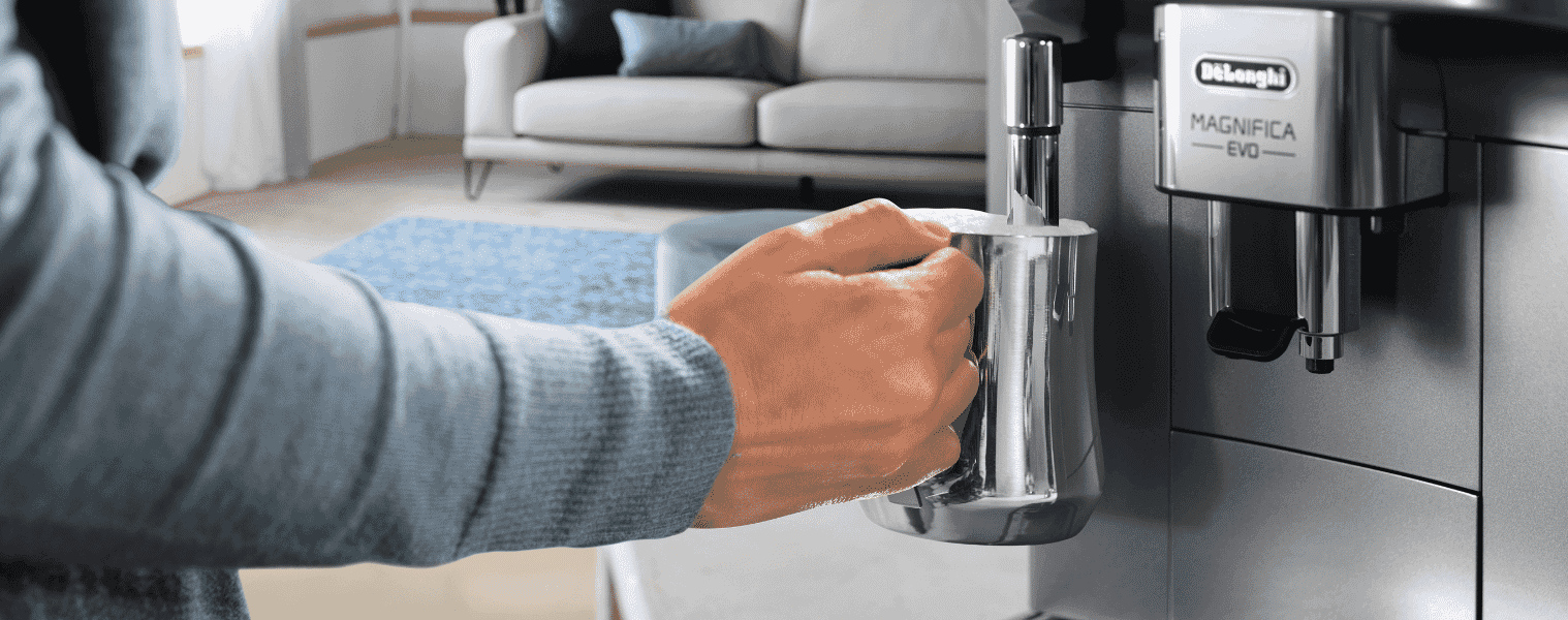 A lady frothing milk with her Delonghi Magnifica EVO Coffee Machine