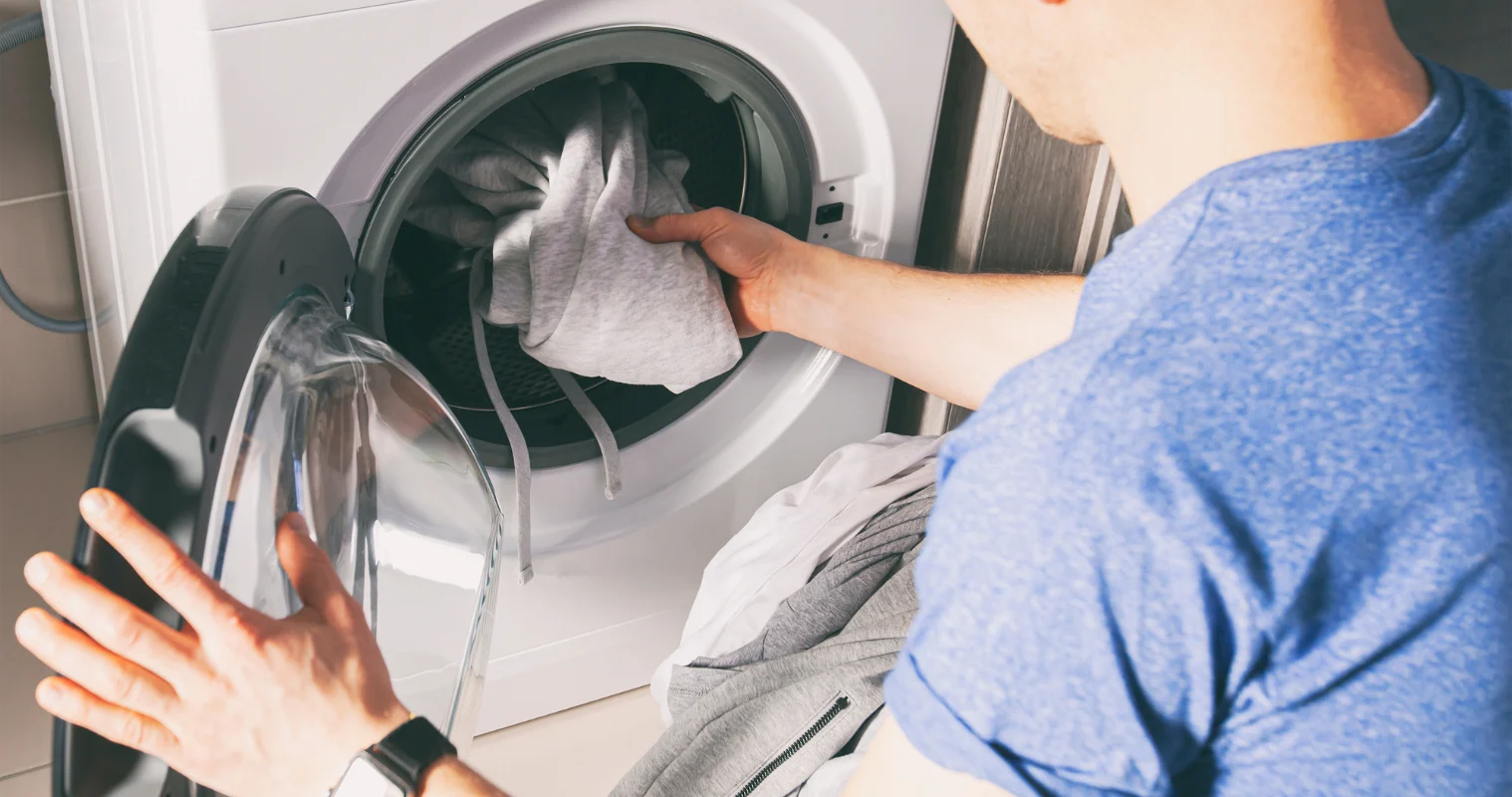 image of a man taking laundry out of a dryer