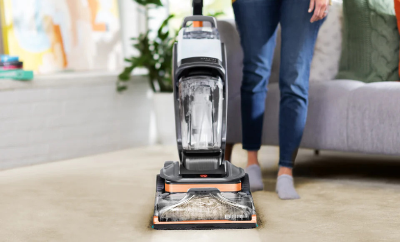 Woman cleaning living room carpet with a BISSELL upright carpet washer