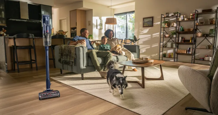 Family sitting on couch with their Bissell Vacuum Cleaner close by