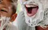 Father and son laughing with shaving foam on their faces