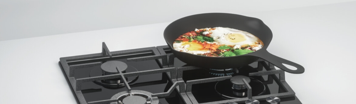 cast iron pan cooking eggs on gas stove
