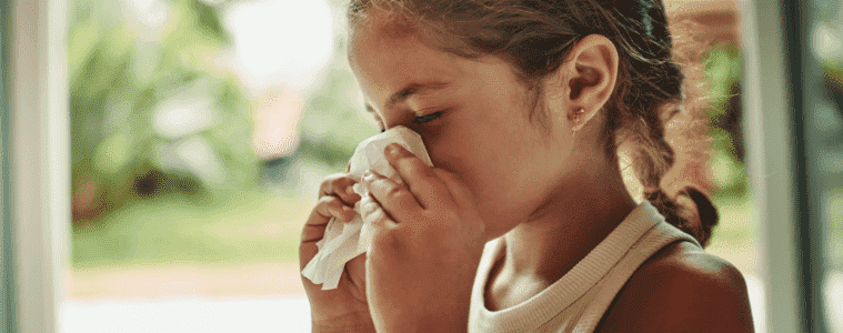 A little girl blows her nose