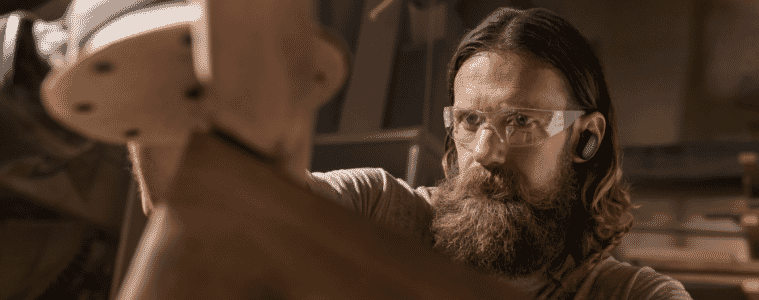 Aman using Bose noise cancelling earbuds while he works