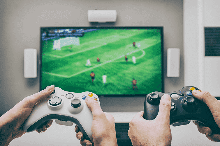 Two sets of hands on video game controllers with a new 4K screen in the background