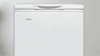A Haier freezer sits against a blank wall