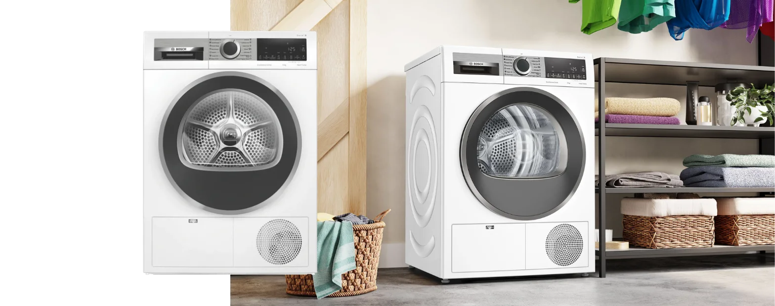 A Bosch washing machine with clean folded clothes on top of it sits next to a basket with clean folded clothes inside of it