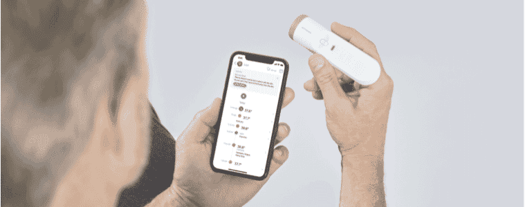 A man adds his temperature from the Withings Thermo Smart Temporal Thermometerto his user profile on his smart phone