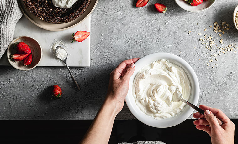 A woman stirring yoghurt in a bowl  