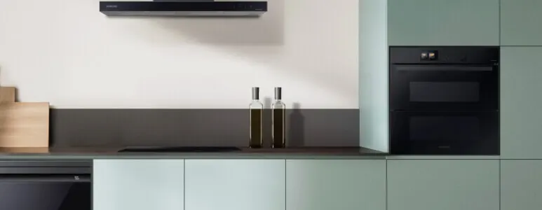 Close up of Samsung Oven in a kitchen built in to the green wall.