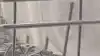 A person uses the handles on the side of the top rack to lower the basket in their LG QuadWash dishwasher.