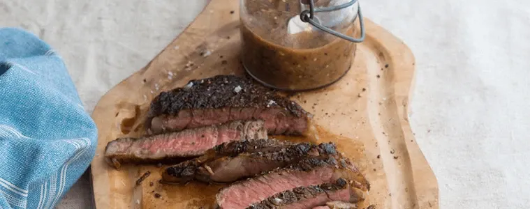 A chopping board with a cut steak