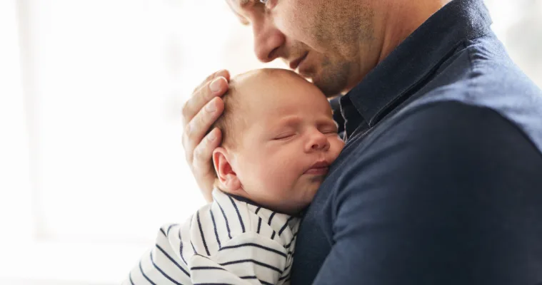 Picture of a father holding his sleeping baby