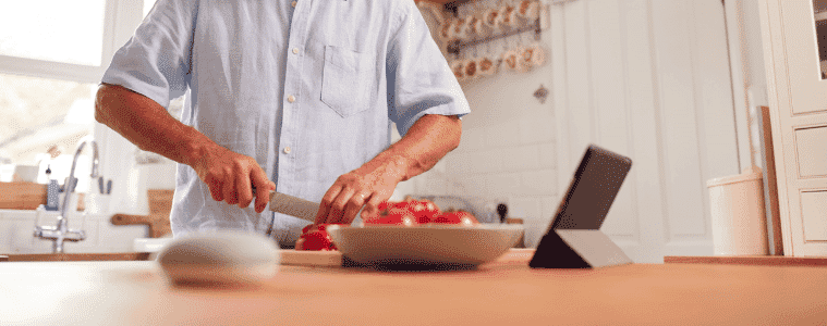 A man follows directions from his smart speaker while cooking