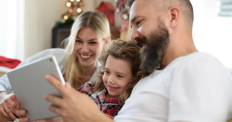 Family at home during Christmas looking at a tablet