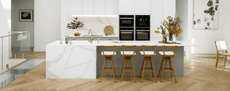 White coastal kitchen with white marblelook island and splashback