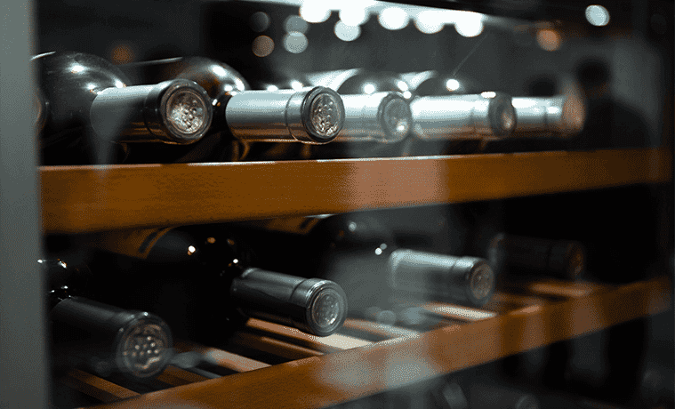 Wine bottles sitting perfectly organised and fresh in a wine fridge