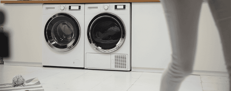 A person walks away from their side by side front loading washer and dryer