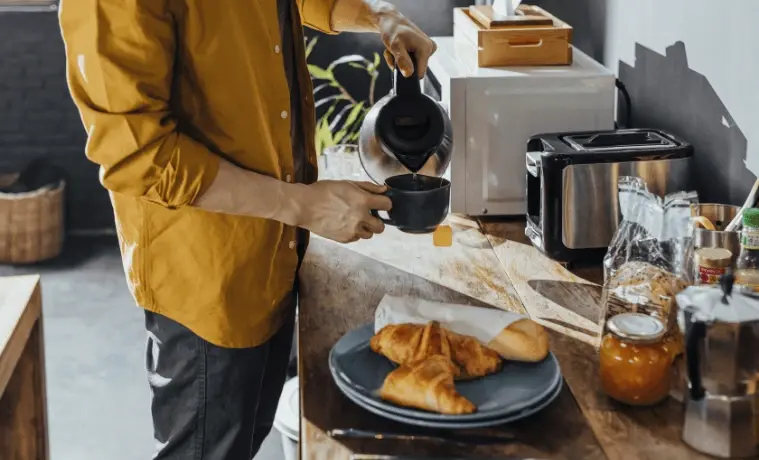 A man using a kettle in a simple modern kitchen