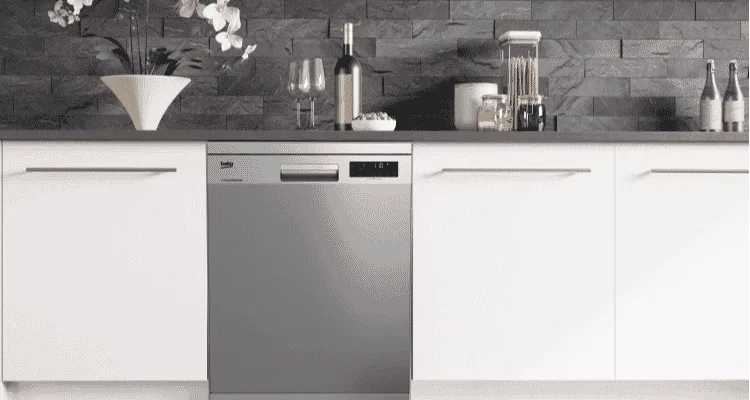 Beko stainless steel dishwasher in between white cabinetry.