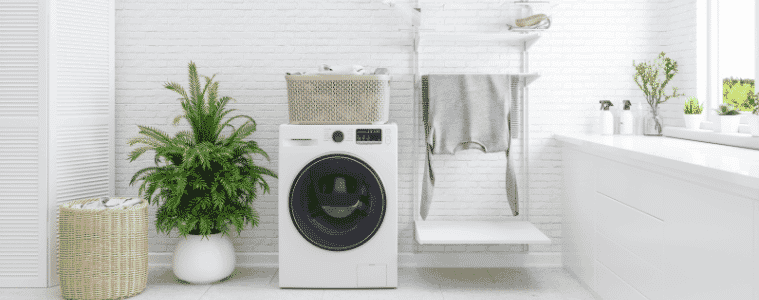 A washing machine in a white clean bathroom