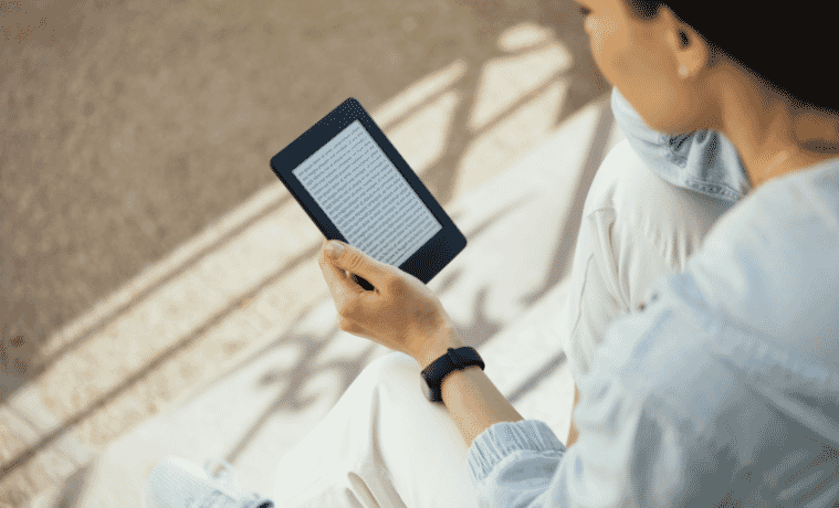 Woman reading an ebook while sitting on steps 