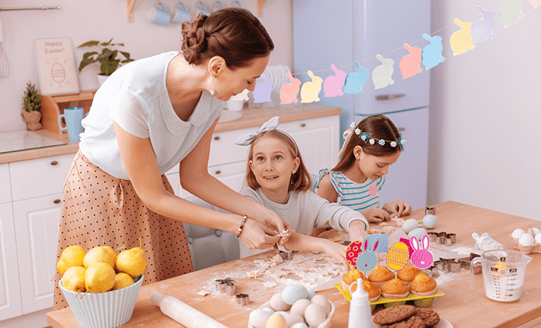 Mother making Easter cookies with her two young daughters