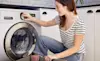 A woman adjusts the settings on her washing machine