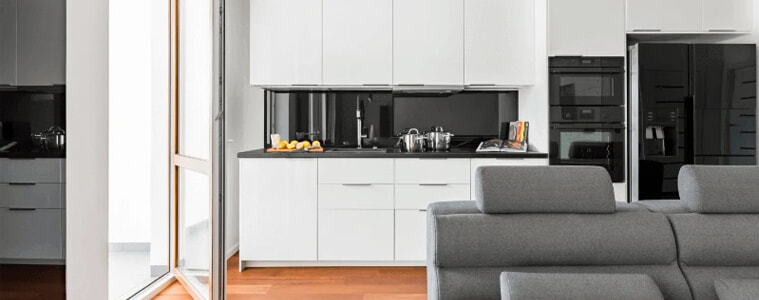 A small white kitchen with a large black smart fridge