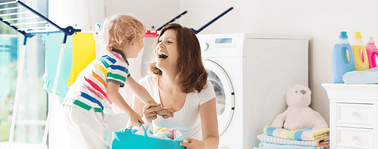 A mother and her young son organise washing together in the laundry
