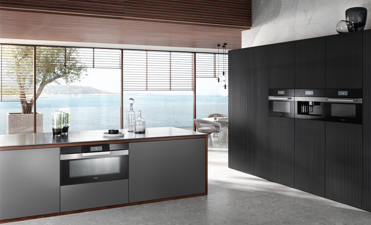A sleek dark kitchen with Miele kitchen appliances