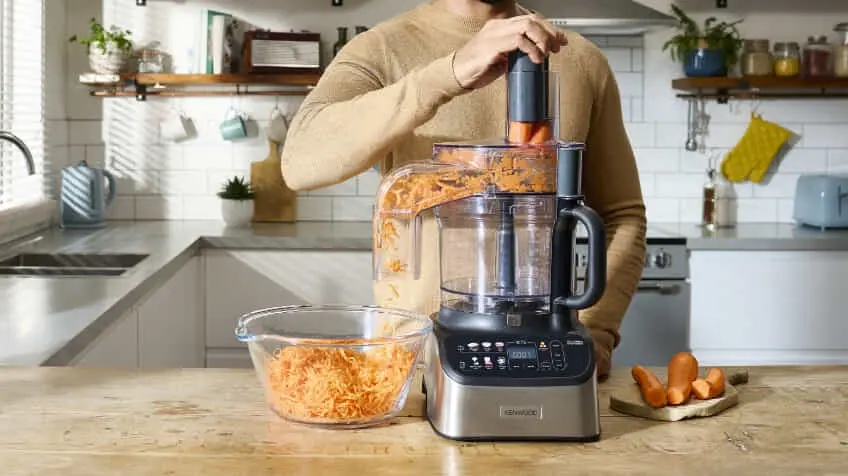person shreds carrot with a Kenwood food processor The Good Guys
