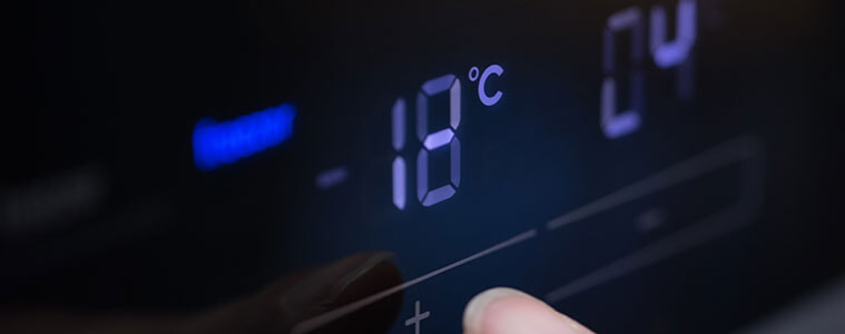 Closeup of a man setting the  temperature on a digital control panel in a fridge