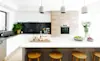 Modern open plan kitchen with chunky wooden stools and timberlook oven feature wall
