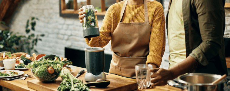 a man and a woman making a green smoothie in winter 