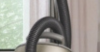 man cleans living room with Miele Duoflex vacuum