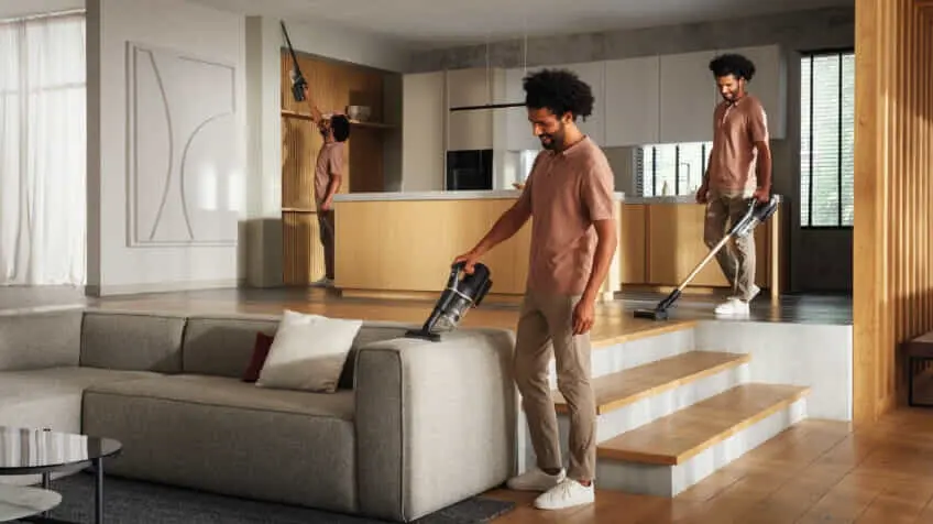 man cleans living room with Miele Duoflex vacuum