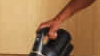 man cleans living room with Miele Duoflex vacuum