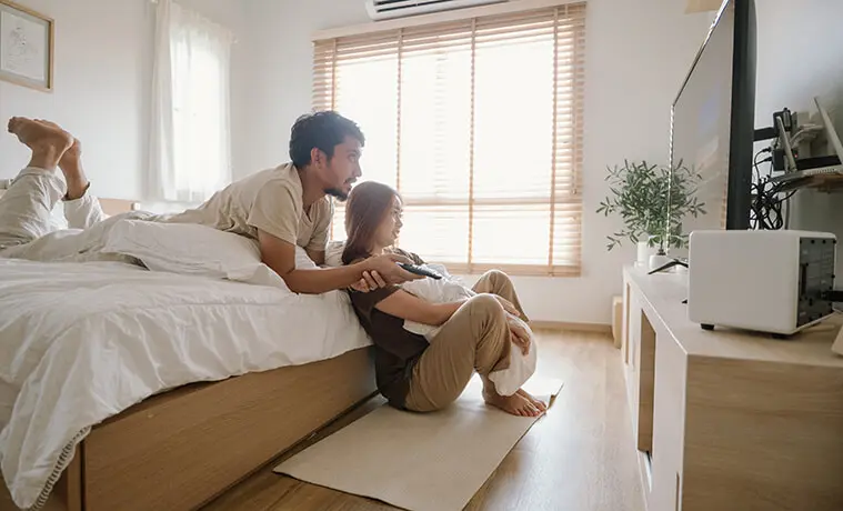 Couple watching TV in their bedroom