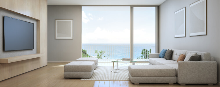 A huge TV in a living room by the ocean