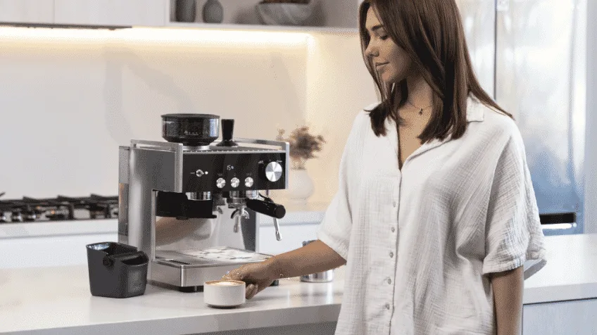 A person enjoying a coffee made with the Sunbeam Origins Espresso machine