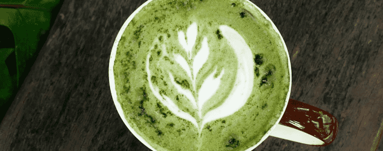 an over shot of a matcha latte with foam art 