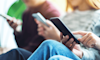 Teens using phones together 