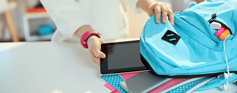 A student pulls a tablet out of their back