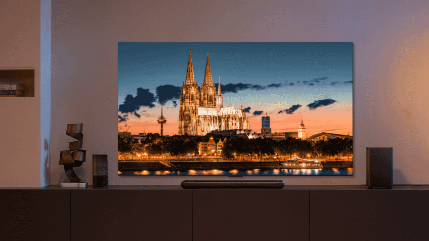 A snowy setting is displayed on a TCL 4K Ultra HD TV in a warm and cosy living room